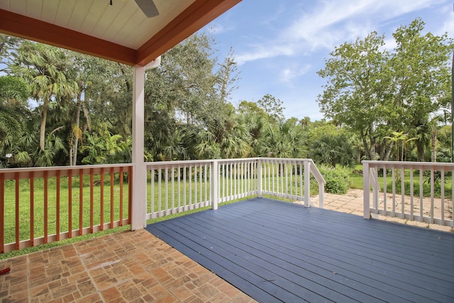 wooden terrace featuring a lawn and ceiling fan