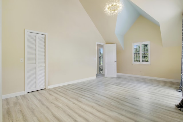 interior space featuring light hardwood / wood-style flooring, high vaulted ceiling, and an inviting chandelier