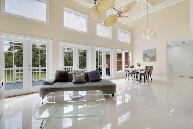 sunroom / solarium with ceiling fan with notable chandelier and french doors