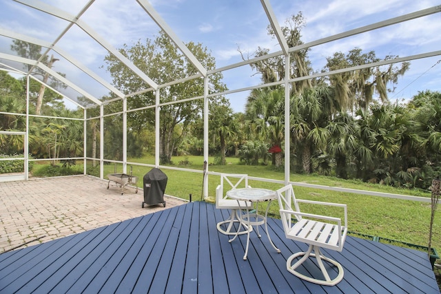 wooden terrace with a lanai, grilling area, a patio area, and a yard