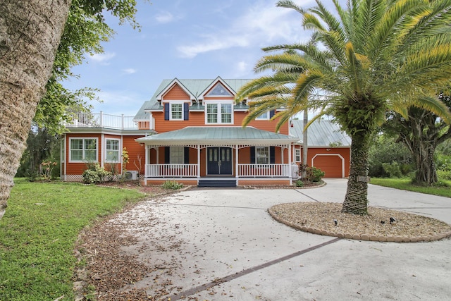 view of front of property featuring a porch, a garage, and a front lawn