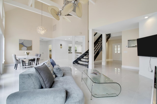 living room featuring tile patterned floors, baseboards, a towering ceiling, and stairs