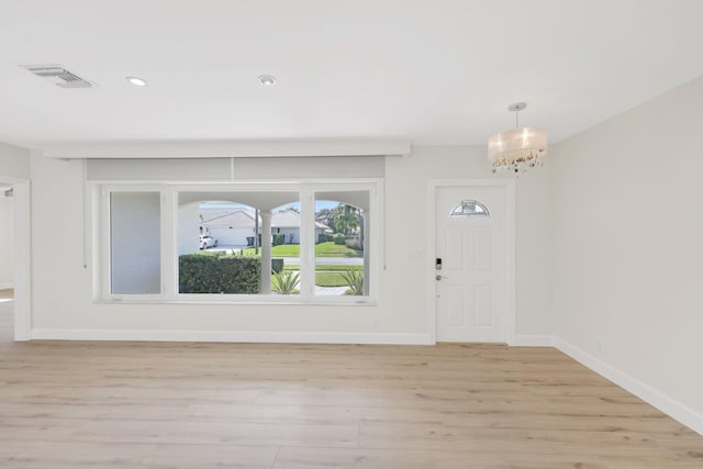 foyer entrance featuring a notable chandelier and light hardwood / wood-style floors