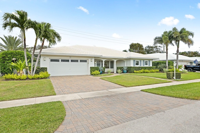 ranch-style home with a garage and a front lawn