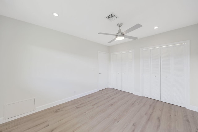 unfurnished bedroom with multiple closets, ceiling fan, and light hardwood / wood-style floors