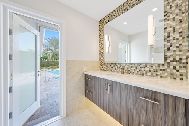 bathroom with tile patterned flooring, vanity, and tile walls