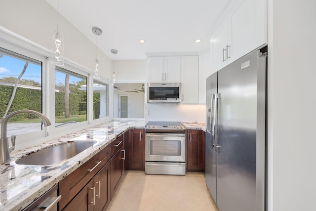 kitchen featuring sink, hanging light fixtures, ceiling fan, white cabinetry, and stainless steel appliances