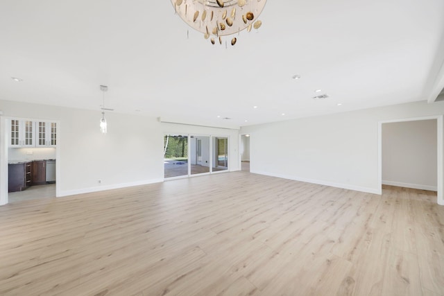 unfurnished living room with light hardwood / wood-style flooring and a chandelier