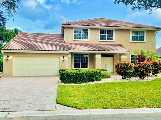 mediterranean / spanish-style home with a front yard and a garage