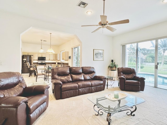 living room featuring light carpet and ceiling fan