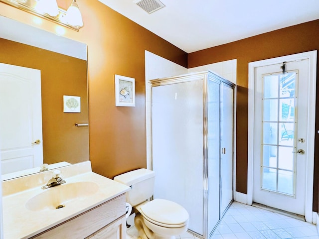 bathroom with toilet, a shower with door, vanity, and tile patterned flooring