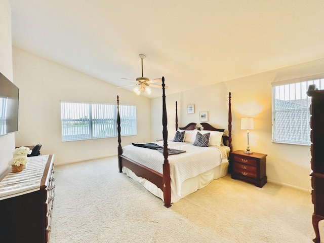 carpeted bedroom with multiple windows, ceiling fan, and vaulted ceiling