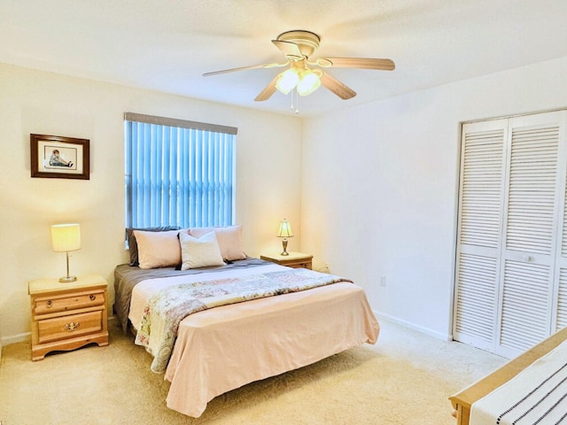 bedroom with a closet, ceiling fan, and light colored carpet