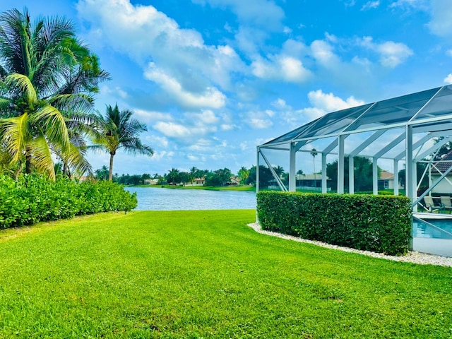 view of yard with a lanai and a water view