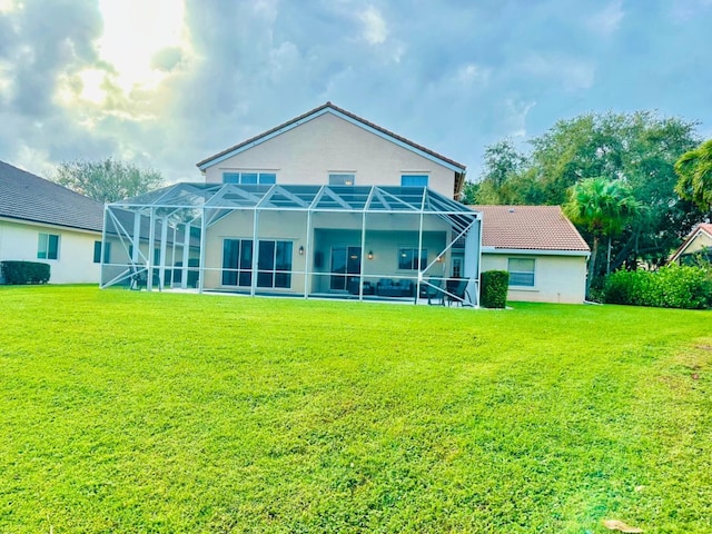 rear view of property with glass enclosure and a lawn