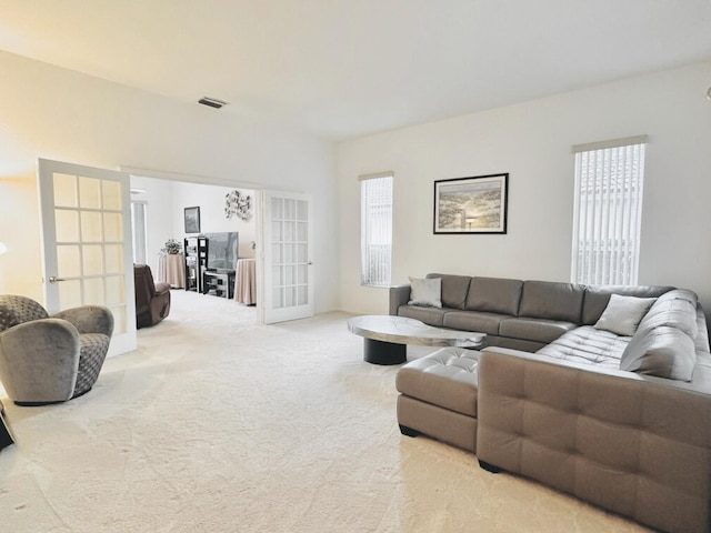 living room featuring french doors and light colored carpet