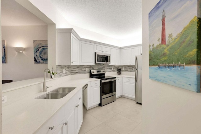 kitchen with decorative backsplash, appliances with stainless steel finishes, white cabinetry, and sink