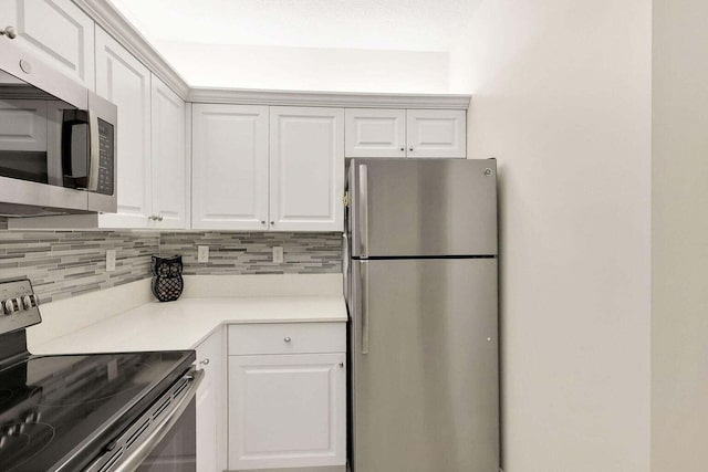 kitchen featuring white cabinets, appliances with stainless steel finishes, and tasteful backsplash