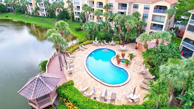 view of swimming pool featuring a water view and a patio