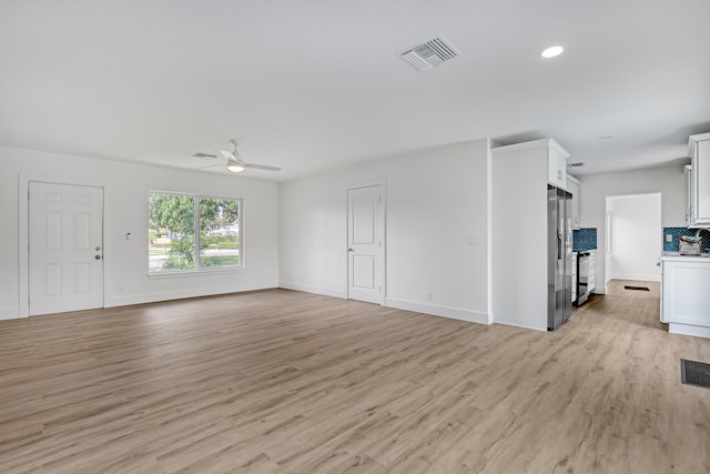 unfurnished living room with ceiling fan and light hardwood / wood-style flooring