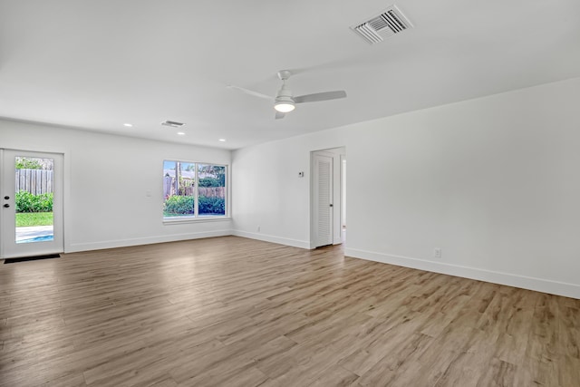 empty room with french doors, light wood-type flooring, ceiling fan, and a healthy amount of sunlight