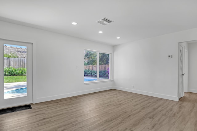 unfurnished room featuring plenty of natural light and light wood-type flooring