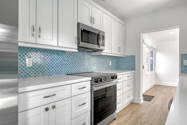 kitchen with stainless steel appliances, tasteful backsplash, light wood-type flooring, white cabinets, and ornamental molding