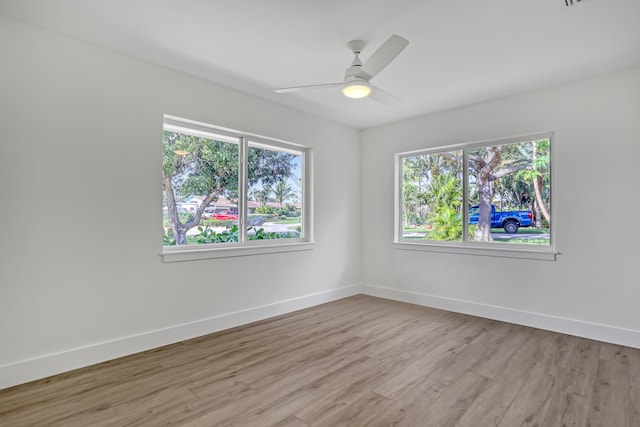 empty room featuring light wood-type flooring, ceiling fan, and a healthy amount of sunlight