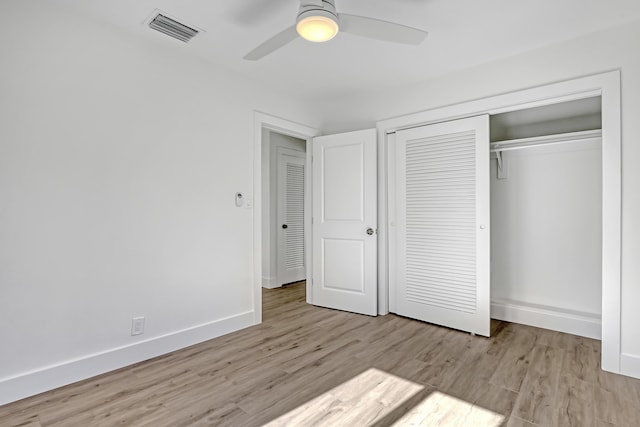 unfurnished bedroom with ceiling fan, a closet, and light wood-type flooring