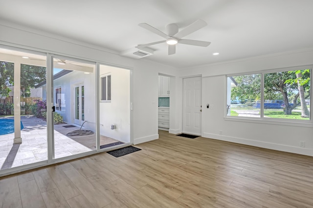 unfurnished room featuring light hardwood / wood-style floors, ceiling fan, and crown molding