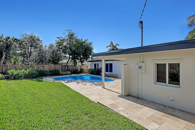 view of pool with a patio area and a lawn