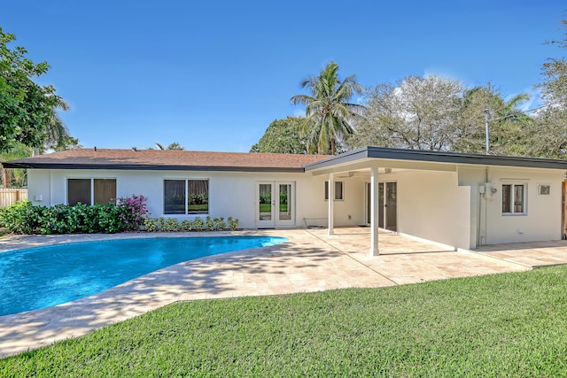 rear view of property with a yard, a patio, and french doors