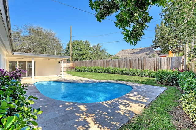 view of pool featuring ceiling fan, a yard, and a patio