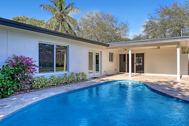 view of swimming pool featuring ceiling fan, a patio, and french doors