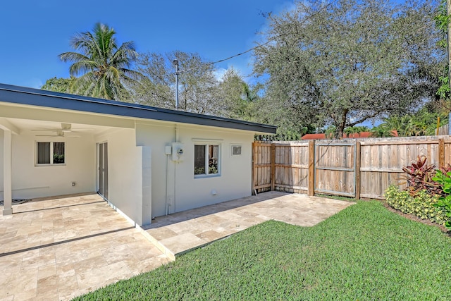 exterior space with ceiling fan, a yard, and a patio