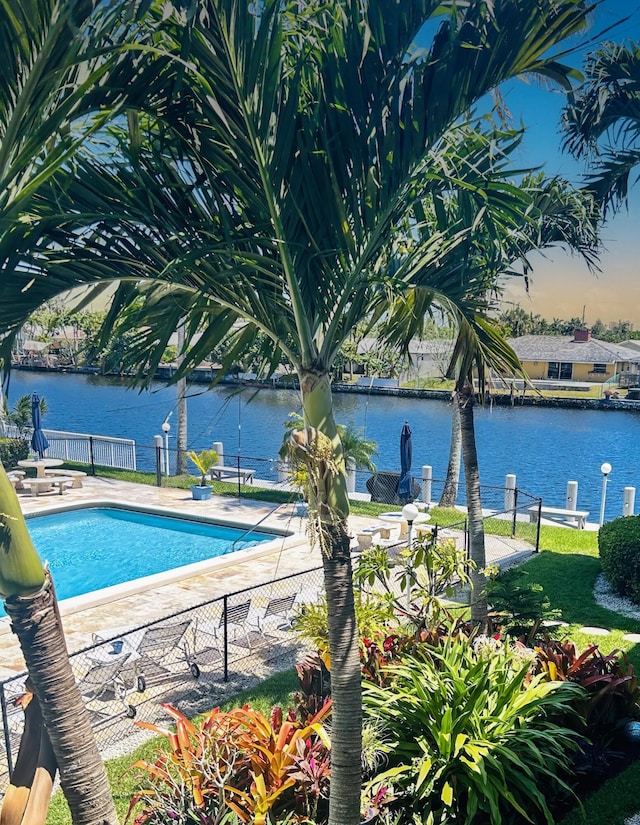 view of swimming pool featuring a patio area and a water view