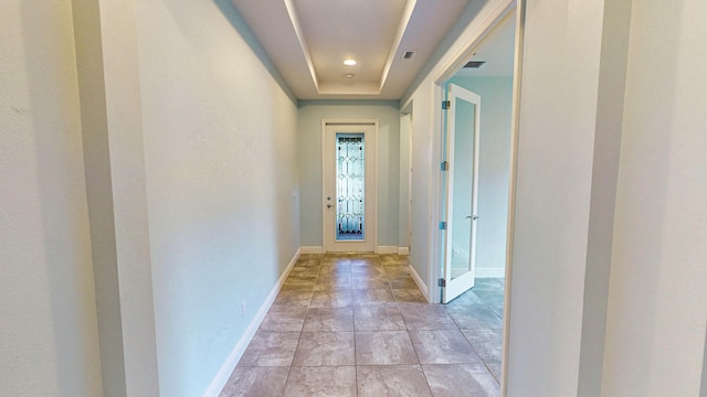 doorway to outside featuring a tray ceiling