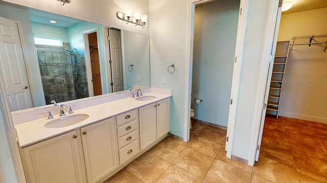 bathroom with tile patterned flooring, vanity, toilet, and walk in shower