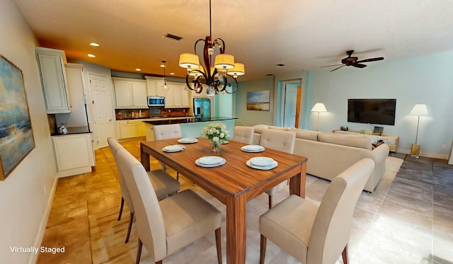 dining space with ceiling fan with notable chandelier