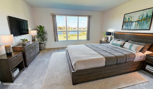 bedroom with a water view and light carpet