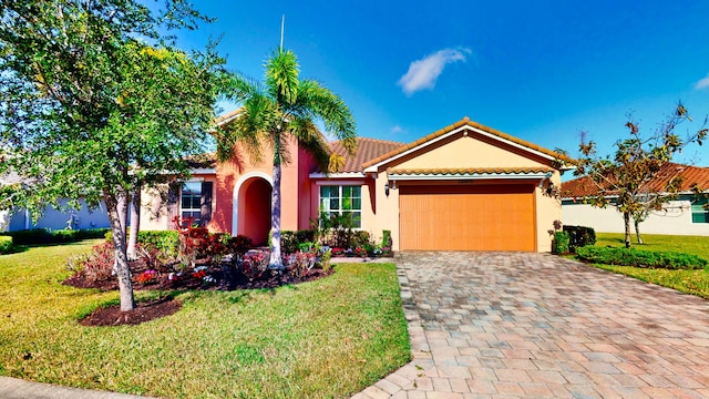 mediterranean / spanish house featuring a garage and a front yard