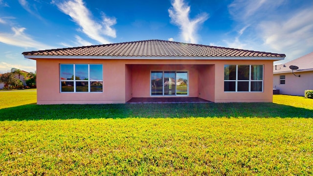 back of property featuring a lawn