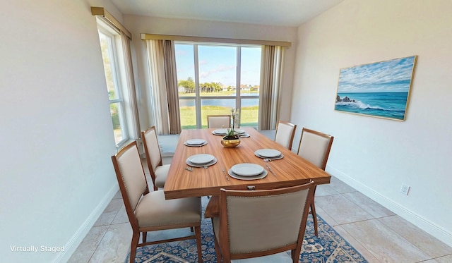 tiled dining area featuring a water view