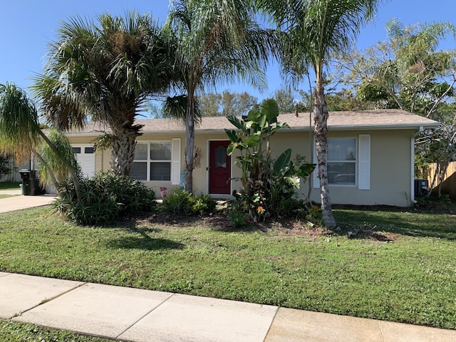 single story home featuring a garage and a front lawn