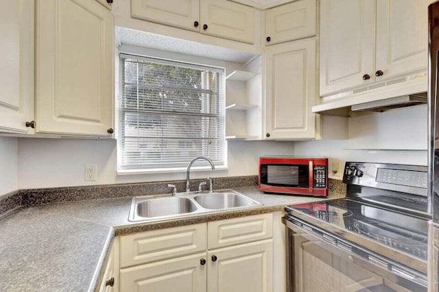 kitchen with cream cabinetry, black electric range oven, and sink