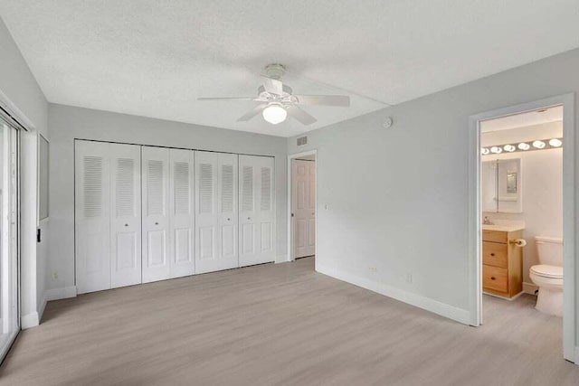 unfurnished bedroom featuring a textured ceiling, ensuite bathroom, ceiling fan, and light hardwood / wood-style floors