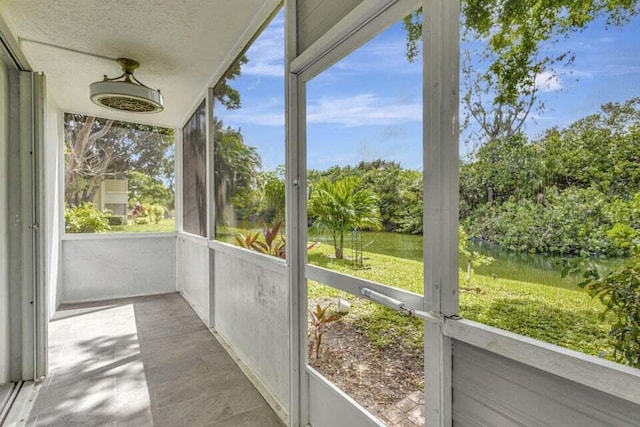 unfurnished sunroom featuring a water view