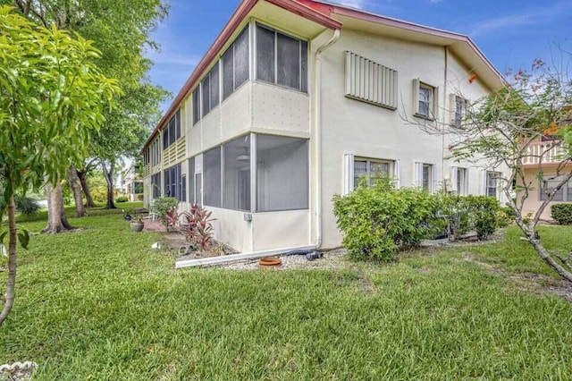 view of property exterior featuring a yard and a sunroom