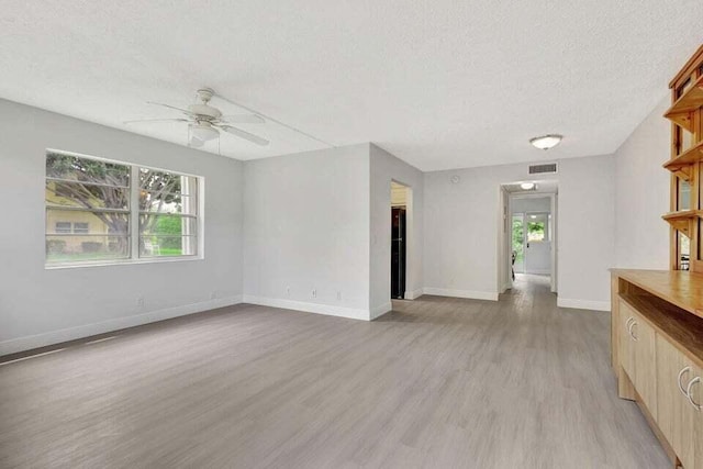 unfurnished living room featuring a textured ceiling, light wood-type flooring, and ceiling fan