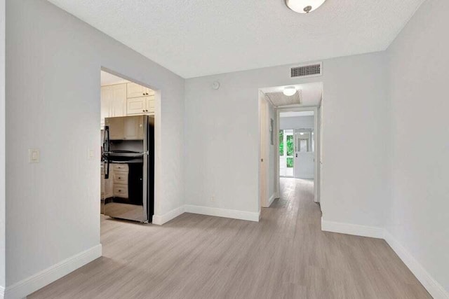 interior space with a textured ceiling and light wood-type flooring